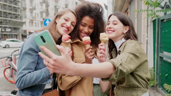 Girlfriends taking selfie in the street, eating icecream