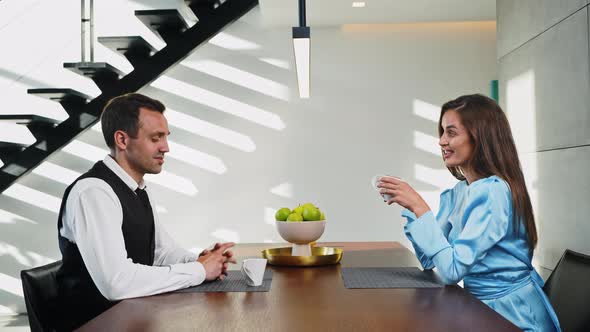 Married Couple Drinking Coffee Early in the Morning at the Table in the Kitchen