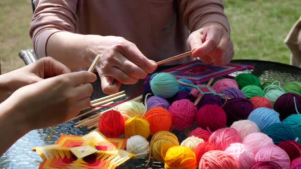 Person demonstrates how to begin making mandala. Mandala weaving teaching