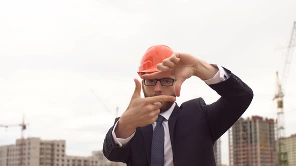 Architect Looking at Building Plans with New Construction