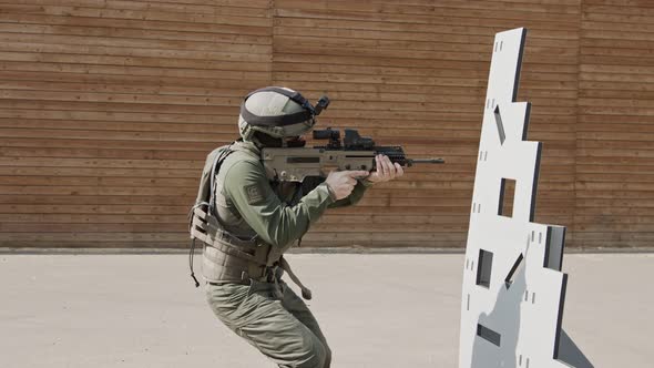 Slow motion of soldier shooting automatic rifle in a range alt