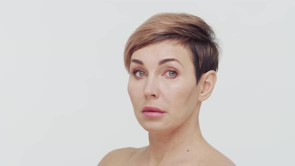 Close-up of middle aged mature woman over white background.