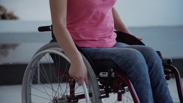 Young Woman in Wheelchair Turning Around at Her House