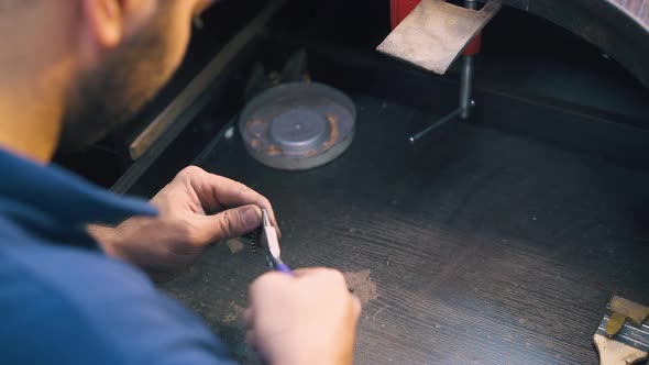 Young Jeweler Works with Gold Spiral at Table Closeup