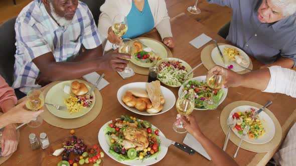 Happy senior diverse people having dinner at retirement home