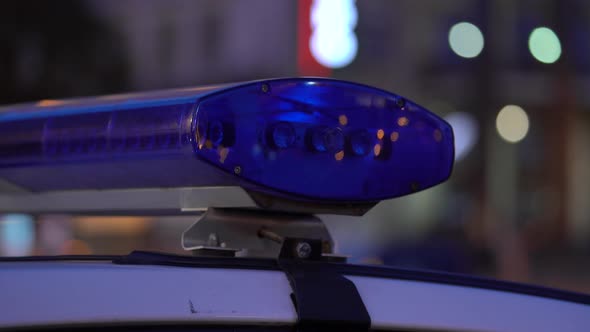 Flashing Flasher on the Roof of a Police Car at Night. Blinker.