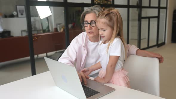 Child and Granny Looking at the Camera with Laptop