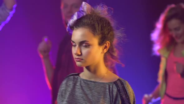 Group of Young People Dancing with Raised Arms in Smoky Club. Slow Motion