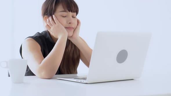 Beautiful young asian woman bored and lazy working on laptop computer at office.