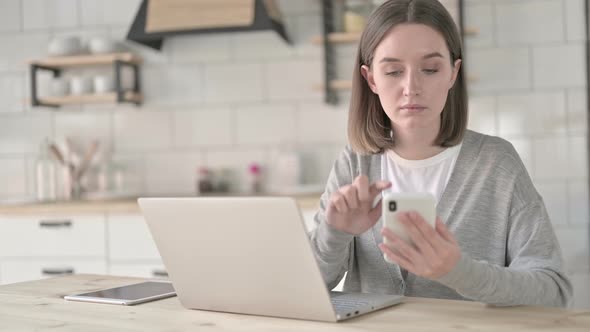 Young Woman Using Smartphone on Office Desk