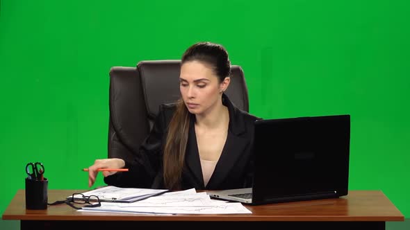 Female Manager Works on a Laptop, Think and Takes Notes. Green Screen Background. Slow Motion