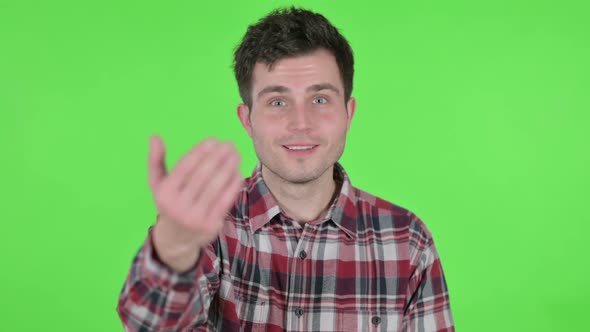Portrait of Young Man Pointing at Camera Inviting Green Chroma Screen