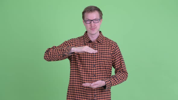 Happy Young Hipster Man Snapping Fingers and Showing Something