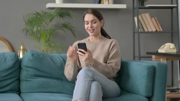 Woman Having Success on Smartphone at Home