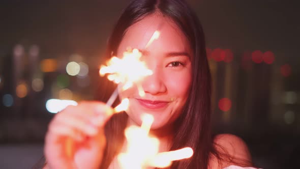 Young asian woman with sparklers is dancing and celebrating a new year.