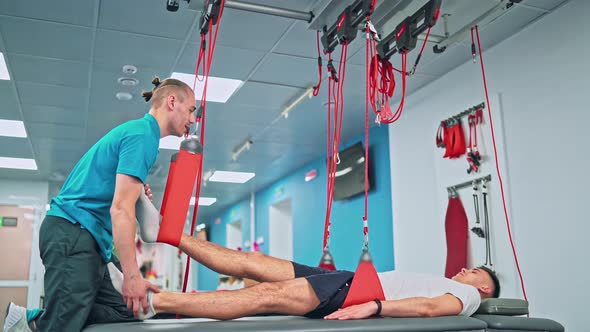 Young Man Doing Exercises Under Physiotherapist Supervision