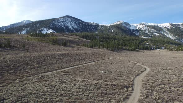 Aerial shot of young woman trail running in the mountains.