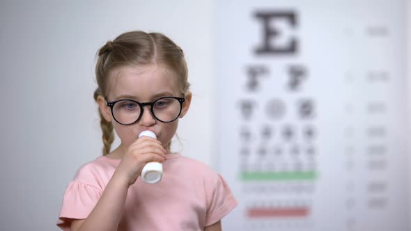 Cheerful Kid in Glasses Drinking Delicious Vitamin Syrup to Improve Vision