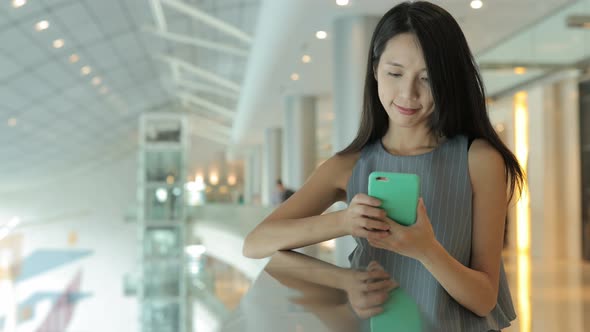 Woman using mobile phone in shopping mall