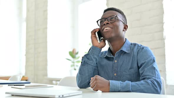 Smiling Young African Man Talking on Smartphone