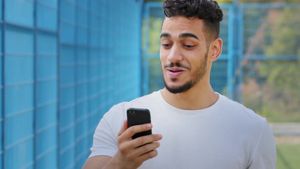Happy Young Middle Eastern Arabic Athlete in Summer Sportswear Making Video Call Using Virtual App