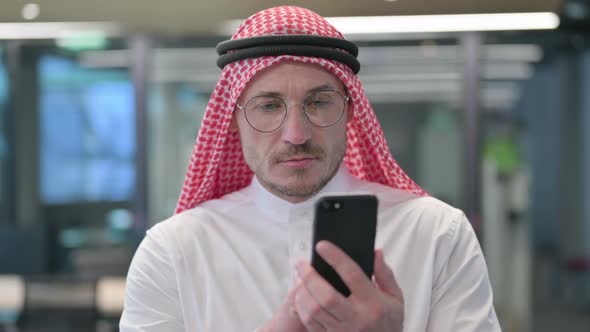 Middle Aged Arab Man using Smartphone