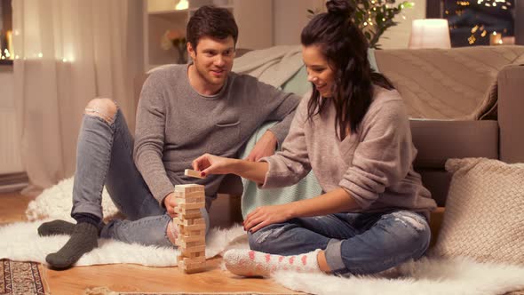 Happy Couple Playing Block-stacking Game at Home