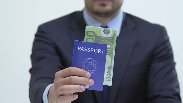 Male in Suit Showing Blue Passport With Euros Banknotes, Labor Migration to EU