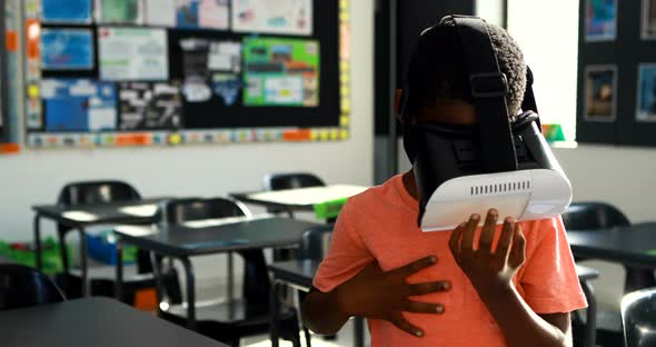 Schoolboy using virtual reality headset in classroom 4k