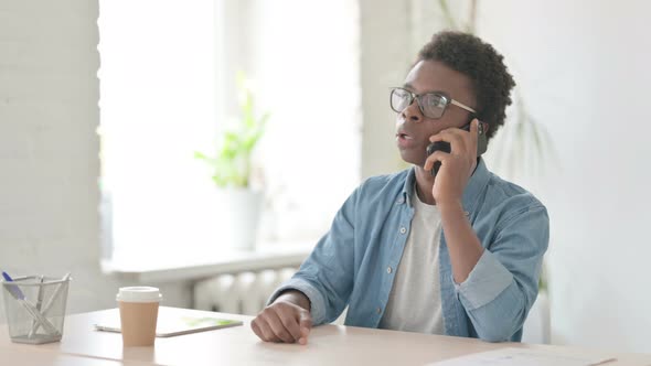 Young African Man Talking on Phone in Office