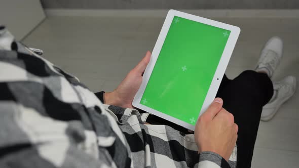 Man Sitting on Chair and Using Digital Tablet with Green Screen Chroma Key