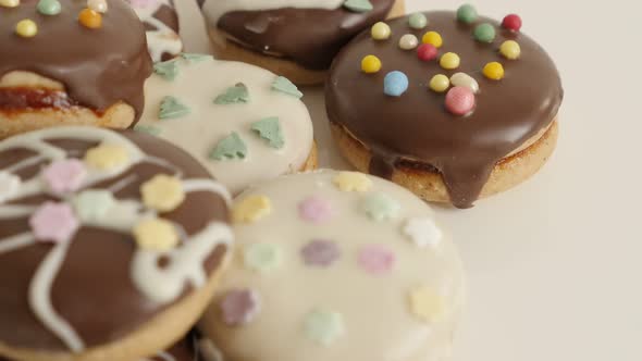 Tilting over assorted teacakes close-up 4K 2160p 30fps UltraHD  footage - Cookies with sprinkles on 