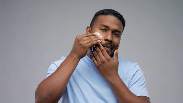 African American Man Cleaning Face with Cotton Pad