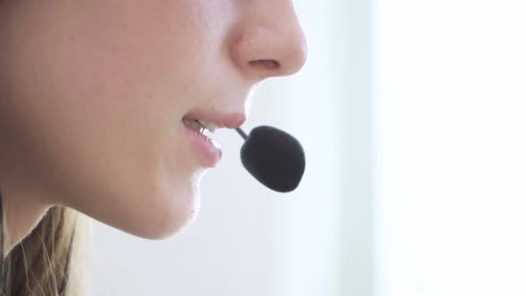 Closeup of the Face of a Young Girl Wearing Headphones Who Communicates Online Explains Teaches