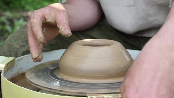Male Potter of Caucasian Ethnicity Makes a Brown Clay Pot Moistens Clay and Draws a Mold