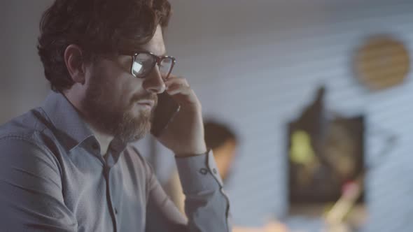 Man Talking on Phone while Working Late in Office