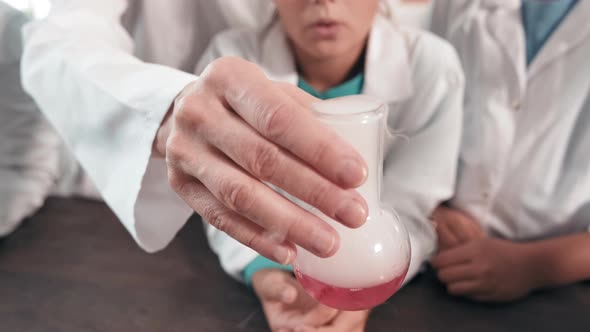 Unrecognizable Teacher Showing Chemistry Experiment to Curious Kids