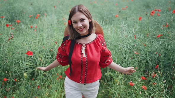 Young Pretty Woman Smiling to Camera in Poppies Red Field