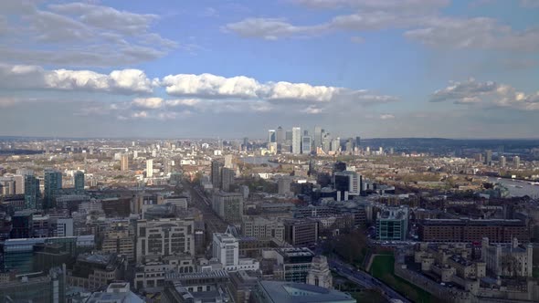 Aerial panning shot showing London Canary Wharf Cityscape with high rising buildings and River Thame