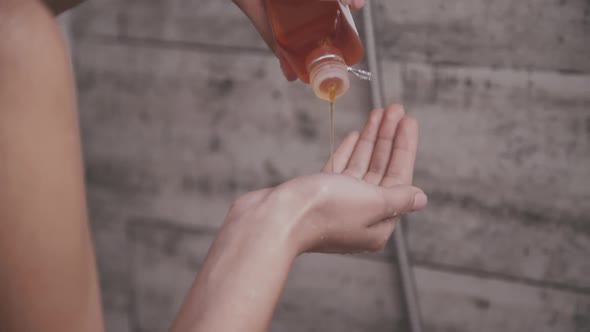 Female Hand Pouring Shampoo Into Palm During Taking a Shower