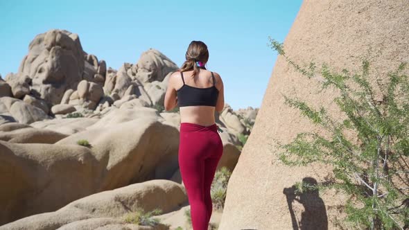 Female photographer at Joshua Tree, California, taking landscape photos, slow motion tracking