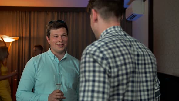 Two Smiling Guys Speaking at Party