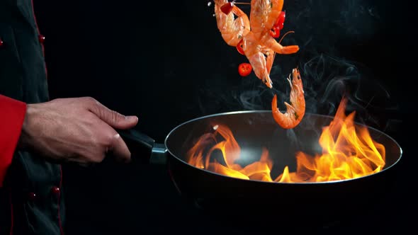 Super Slow Motion Shot of Chef Holding Frying Pan and Falling Shrimps Into Fire at 1000Fps