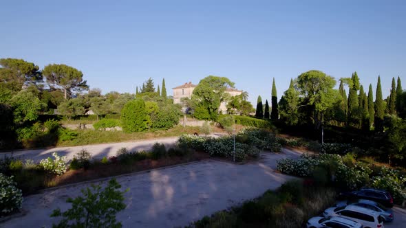 Big villa being shown that is hidden behind some trees.