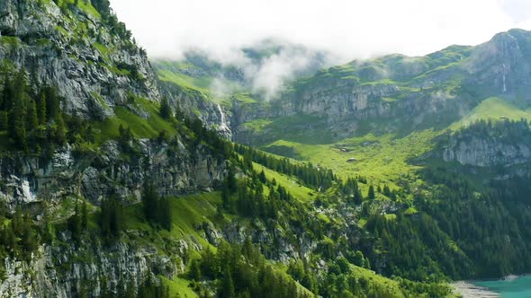 Aerial view of a beautiful Swiss mountainscape with green fields, trees and hills
