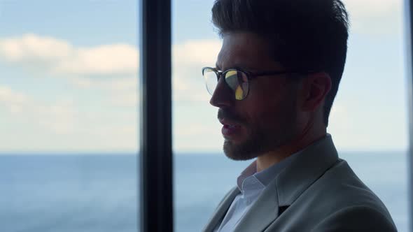 Smiling Businessman Reading Documents at Sea View Closeup