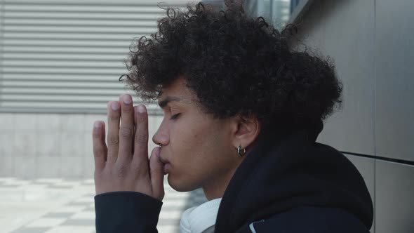 Afro American Boy in Black Hoodie Praying Holding Hands In Prayer Gesture