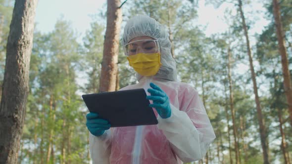 Female Scientist in Protective Suit Working on Tablet Pc