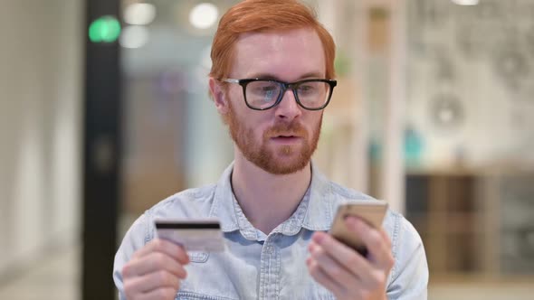 Young Redhead Man with Online Payment Success on Smartphone