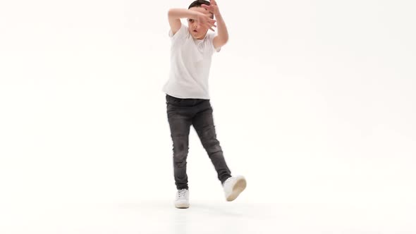 Little Boy Is Dancing a Modern Dance on the White Background in Black Leather Jackets and Jeans